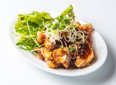 Lezzetli kareage tavuk tabağı taze yeşil salata ve soğan restoran menüleri ve ağız sulandıran sosyal medya yemek paylaşımları için mükemmeldir.