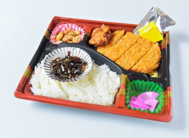 Lezzetli Japon bento kutusu. Kızarmış tavuk, pilav, zencefil turşusu, yosun salatası ve lezzetli bir yemek için fıstık.