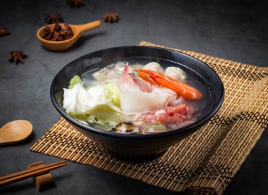 Taze karides, balık, istiridye ve sebzelerle kaynayan deniz ürünleri lapası Asya mutfağının promosyonları için mükemmel.