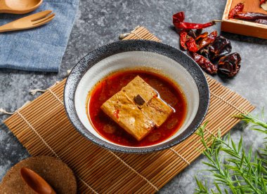 Koyu kırmızı acı biber yağına batırılmış terbiye edilmiş soya peynirinin cesur ve canlı sıcaklığını deneyin. Menüler ve egzotik yemek özellikleri için mükemmeldir..