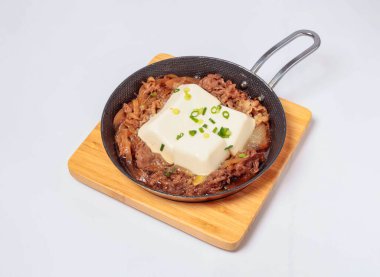 Sukiyaki Tofu Cızırdayan Kore Bulgogi bifteği Erimiş tofu ve yeşil soğanlı beyaz arka planda izole edilmiş soğan