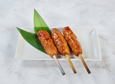 İştah açıcı jöleli et şişleri yeşil yapraklı beyaz bir tabakta servis edilir, bir restoran menüsü ya da mermer arka planda izole edilmiş yemek blogu için mükemmeldir.