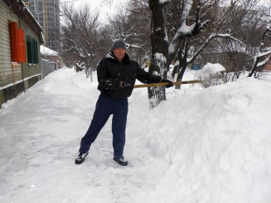 Bir adam kar yoldan temizler