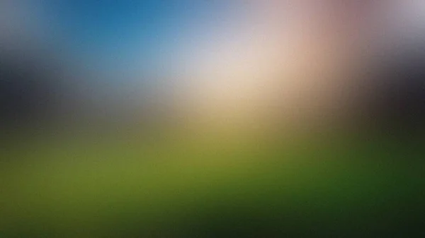 Yeşil çimenler ve yumuşak mavi gökyüzü gradyanı olan bir manzarayı andıran bulanık ve soyut bir arkaplan.
