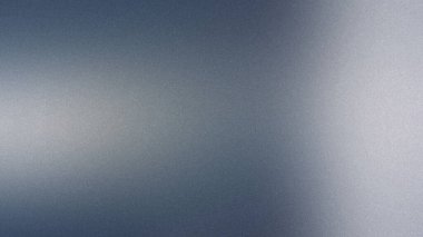 Yumuşak bir mavi ve gri gradyan ince bir tahıl dokusuna sahip ince bir soyut arkaplan oluşturur.