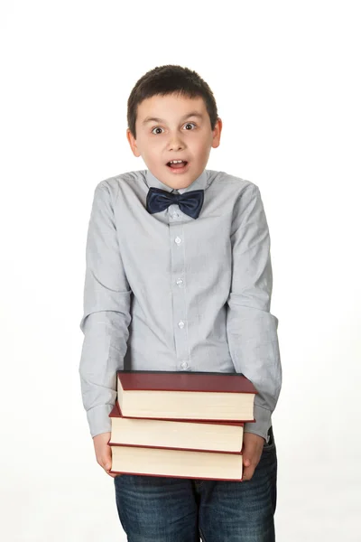 Portrait d'un jeune garçon, enfant, bouleversé, tenant trois gros livre rouge — Photo