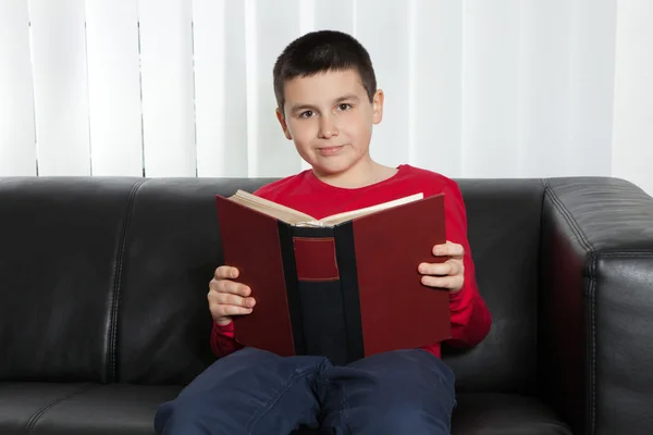 Lycklig pojke läser en bok — Stockfoto