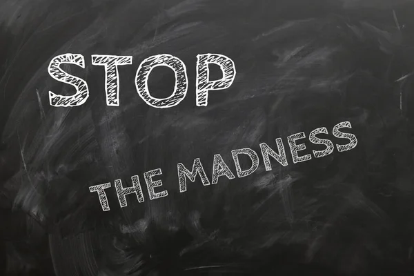 Stop the madness. Sign against false information, bad times, lies - written on a black board.