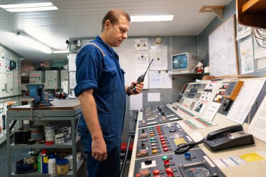 Makine Kontrol Odası ECR 'da telsiz iletişimi üzerine çalışan Deniz Mühendisi.