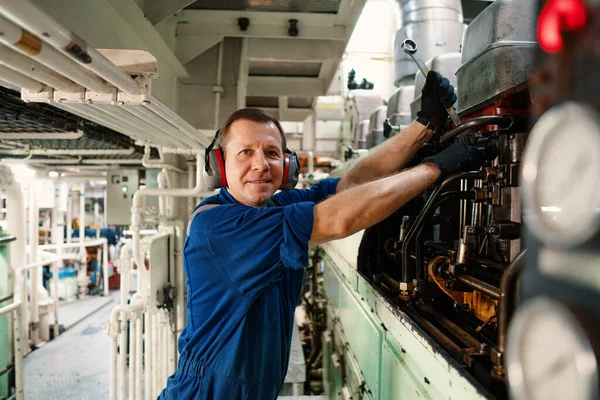 Marine engineer officer controlling vessel enginesand propulsion in engine control room ECR