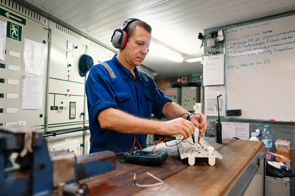 Marine elektrotechnisch ingenieur in machinekamer ECR. Hij werkt in een werkplaats. — Stockfoto