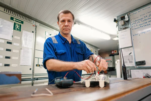 Marine elektrotechnisch ingenieur in machinekamer ECR. Hij werkt in een werkplaats. — Stockfoto