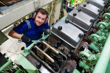 Gemi motorlarını ve itiş gücünü kontrol eden bir deniz mühendisi.