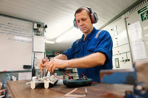 Marine elektrotechnisch ingenieur in machinekamer ECR. Hij werkt in een werkplaats. — Stockfoto