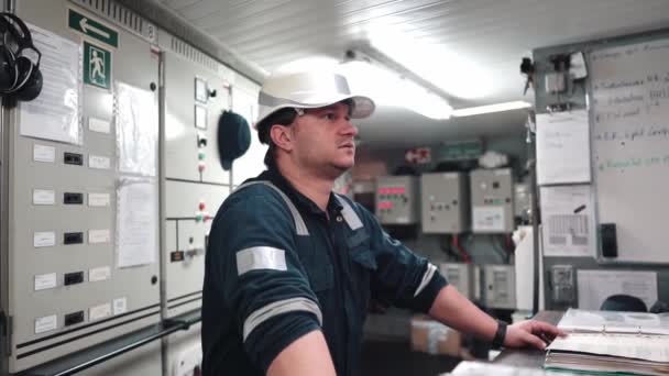 Hajómotorokat és hajtóműveket irányító tengerészmérnök tiszt a gépház vezérlőtermében — Stock videók