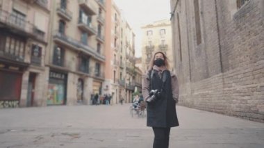 DSR fotoğraf makinesiyle sokakta maskeli bir turist.