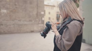 DSR fotoğraf makinesi olan turist kız eski kasabadan geçiyor.