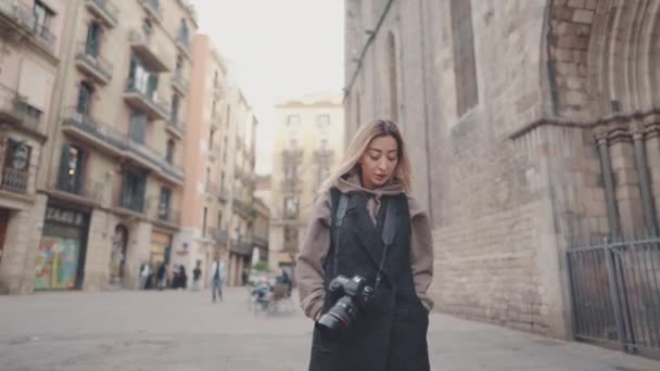 Туристическая девушка с фотокамерой dslr прогулка по старому городу — стоковое видео