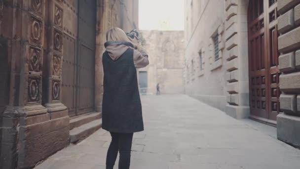 Туристка в маске на улице с фотокамерой dslr — стоковое видео