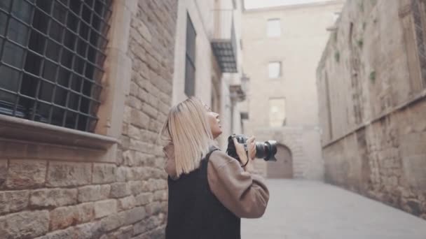 Туристическая девушка с фотокамерой dslr прогулка по старому городу — стоковое видео