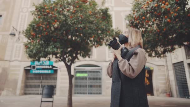 Turista mujer en máscara en la calle con cámara de fotos dslr — Vídeo de stock