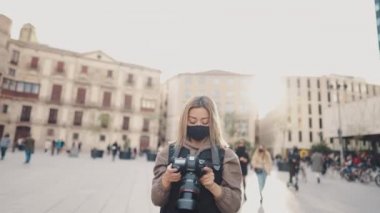 DSR fotoğraf makinesiyle sokakta maskeli bir turist.