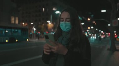 Virüse karşı maske takan kadın model, gece şehirde tek başına dolaşıyor..
