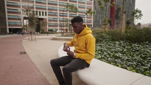 Африканский американец в центре города болтает с мобильником — стоковое видео