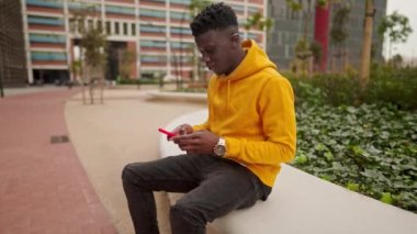 Şehir merkezinde cep telefonuyla sohbet eden Afrikalı Amerikalı bir adam.