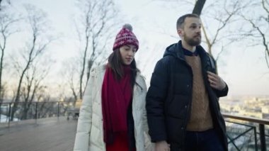 Mutlu romantik, neşeli çift güneşli kış gününde yürüyor.