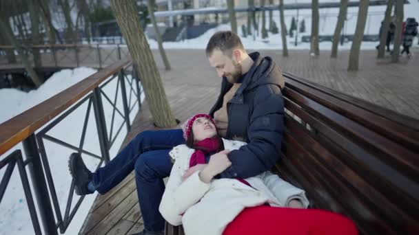 Happy romantic couple haveing a date on the bench at sunny winter day. — Stock Video