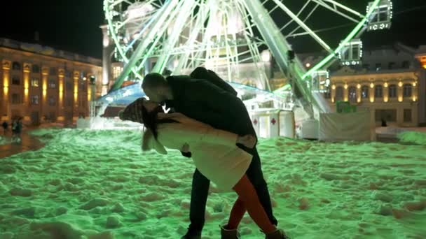 Счастливая романтическая пара играет на заднем плане колеса обозрения — стоковое видео