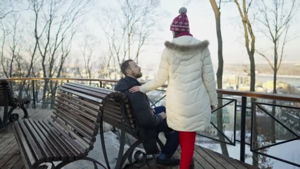 Glückliches romantisches Paar bei einem Date auf der Bank an einem sonnigen Wintertag. — Stockvideo