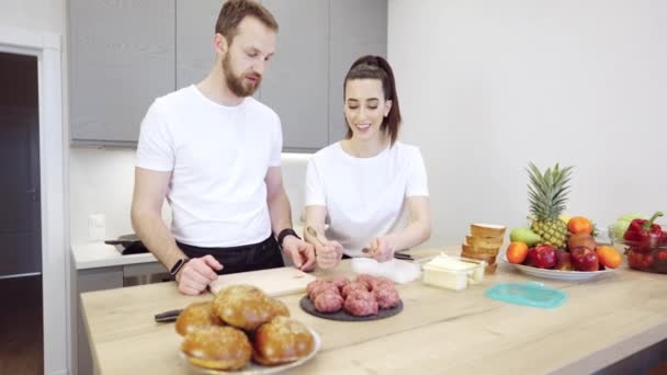 Pareja Praparing hamburguesas de carne en la cocina — Vídeo de stock