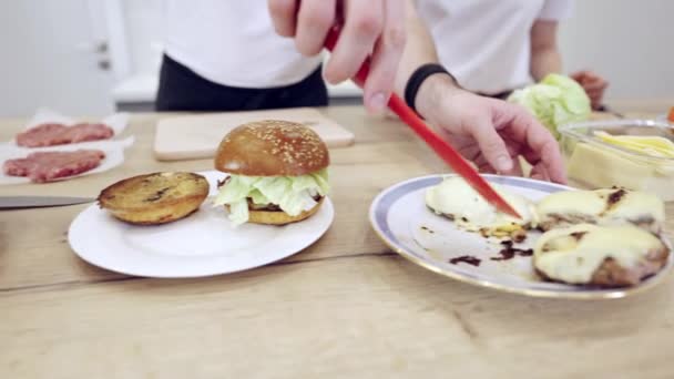 Pareja Praparing hamburguesas de carne en la cocina — Vídeo de stock