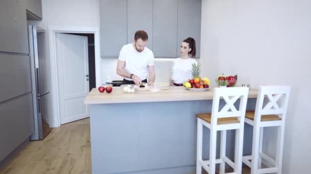 Pareja cocinando juntos en casa en la cocina — Vídeo de stock
