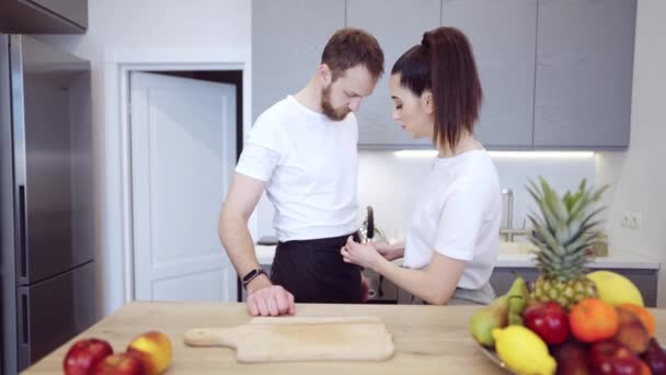 Pareja cocinando juntos en casa en la cocina — Vídeos de Stock