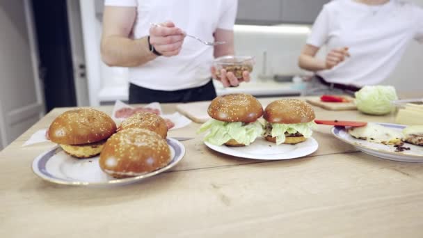 Pareja Praparing hamburguesas de carne en la cocina — Vídeo de stock