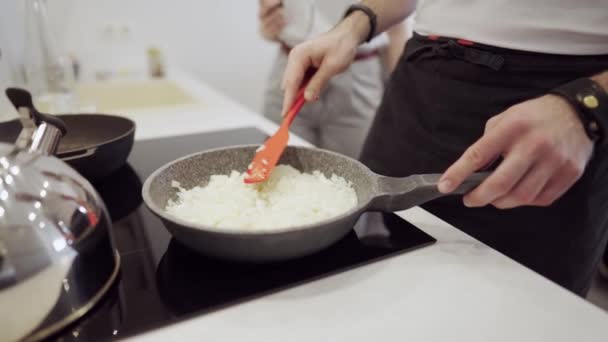 Hombre joven cocinando cebolla en casa en la cocina — Vídeo de stock