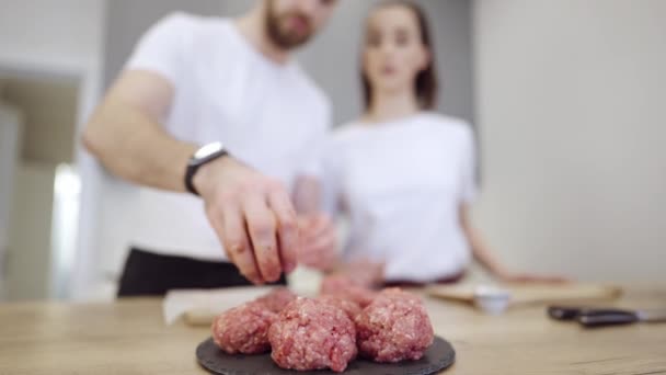 Pareja Praparing hamburguesas de carne en la cocina — Vídeo de stock