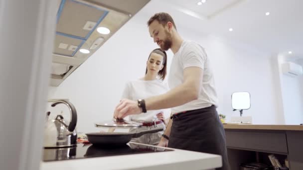 Casal cozinhando bife de salmão juntos em casa — Vídeo de Stock