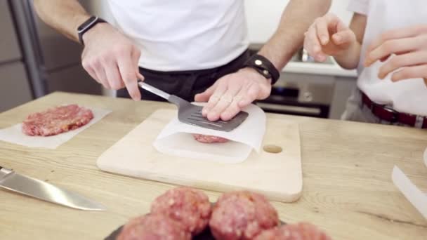 Pareja Praparing hamburguesas de carne en la cocina — Vídeo de stock