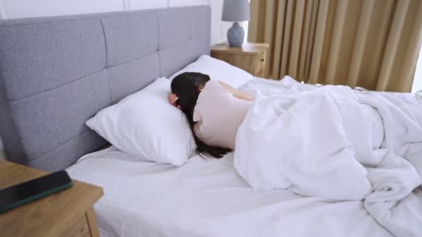 Mujer joven duerme en una cama cómoda — Vídeo de stock