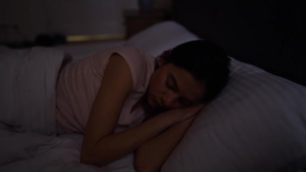 Chica joven se acuesta en la cama — Vídeo de stock