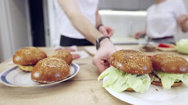 Pareja Praparing hamburguesas de carne en la cocina — Vídeo de stock