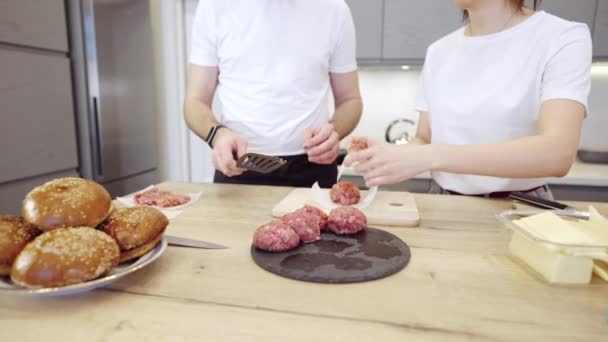 Pareja Praparing hamburguesas de carne en la cocina — Vídeo de stock