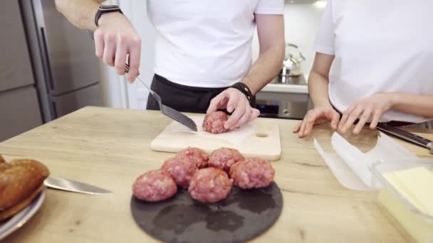 Casal Praparing hambúrgueres de carne na cozinha — Vídeo de Stock