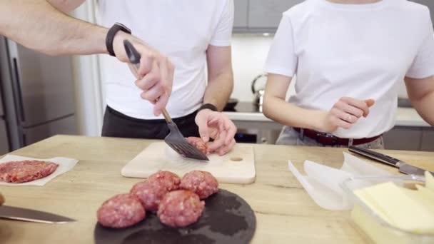 Pareja Praparing hamburguesas de carne en la cocina — Vídeo de stock