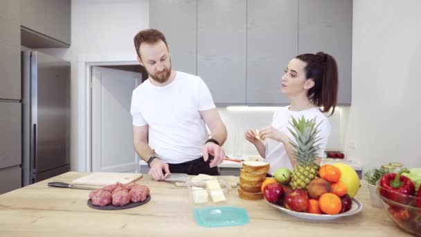 夫婦は台所で肉バーガーを準備します。 — ストック動画
