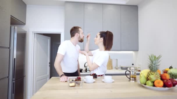 Пара сидящих на кухне, пьющих чай и поедающих чизкейк — стоковое видео